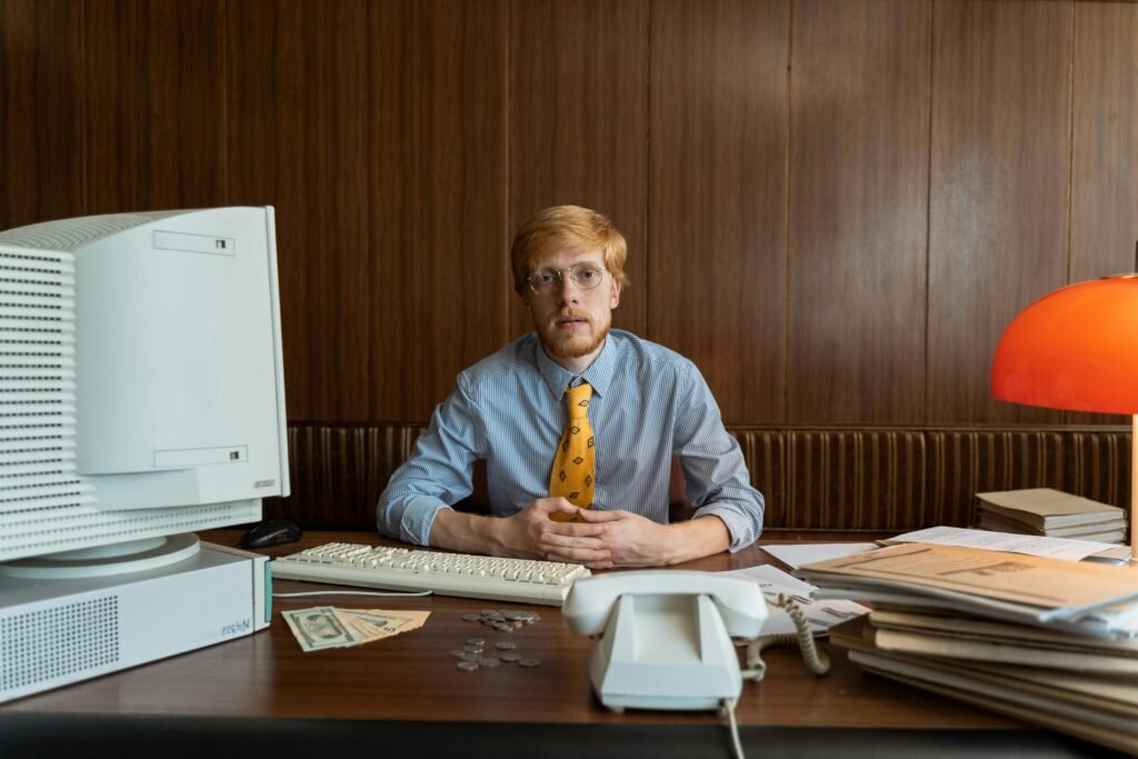 a man sitting at a desk with a computer and money