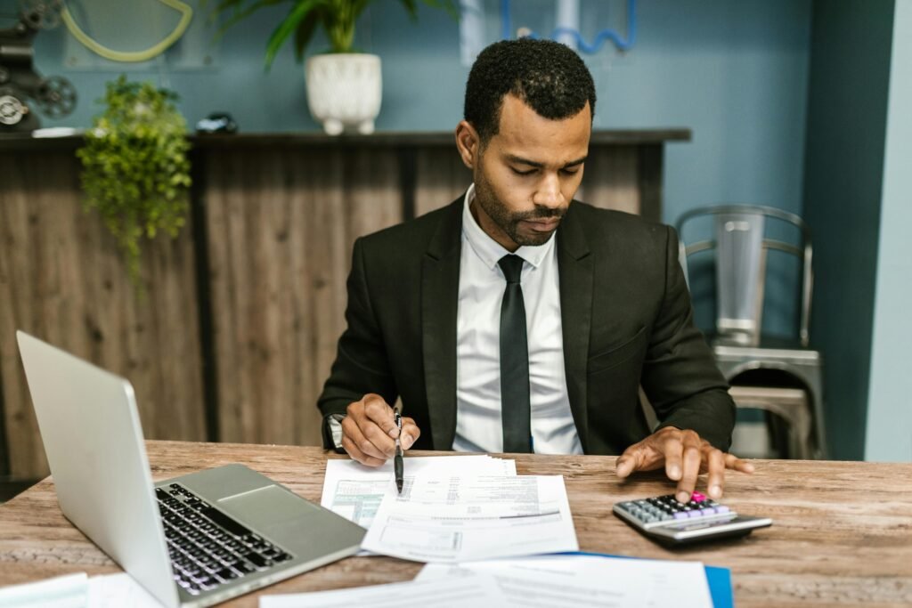 a man in a suit and tie working on a calculator